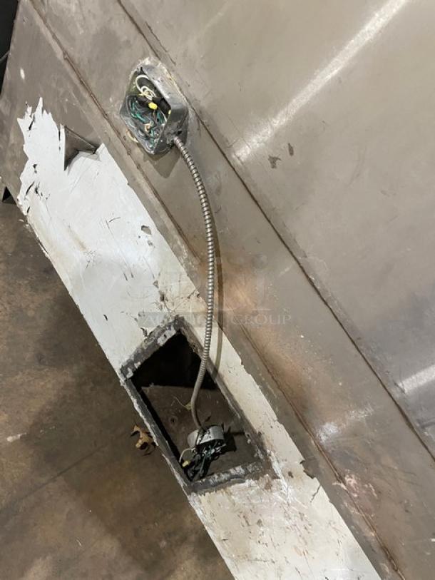 Stainless steel commercial kitchen exhaust hood with filter and electric exhaust fan; visible wiring; used condition.