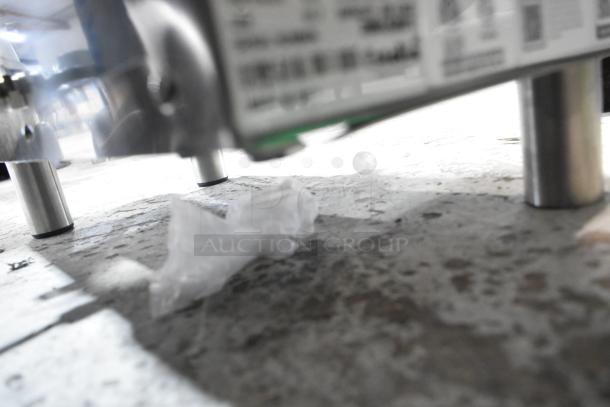 Stainless steel legs of an Estella 348PEM4 pasta extruder machine, showing underside on a concrete surface.