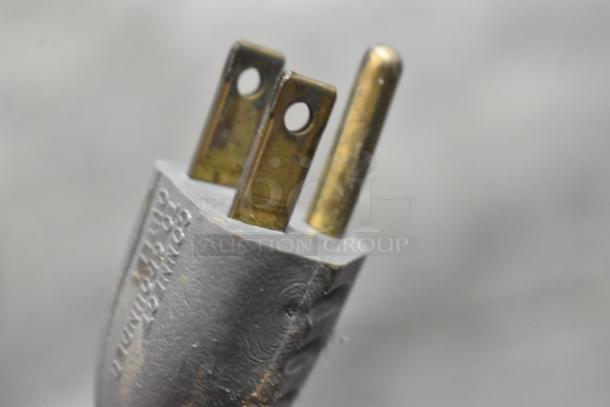 Close-up of a three-prong power plug from a Hobart 84186 Buffalo Chopper, showing metal wear and embossed text.