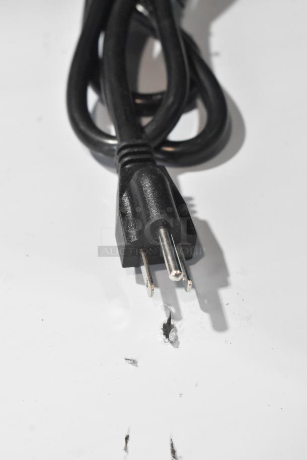 A power cord from the 2025 Avantco 194MCH430A Stainless Steel Ice Machine, showing a three-prong plug on a clean surface.