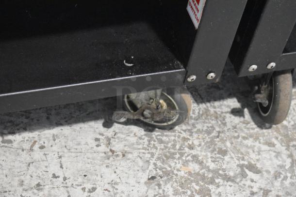 Lakeside metal bakery display case on commercial casters, showing durable wheels. Model for 125 volts, 1 phase use.