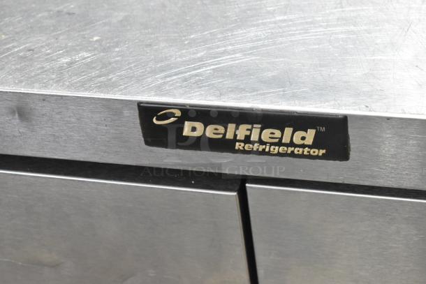 Delfield UCD4464N-12-DD5 stainless steel sandwich salad prep table, features 4 drawers, over shelf, and casters.