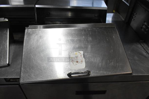 Delfield UCD4464N-12-DD5 stainless steel prep table with overshelf, 4 drawers, used condition, visible label, on casters.