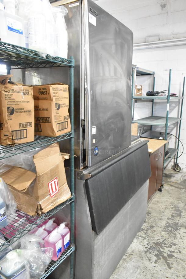 Hoshizaki KM-1340MRH stainless steel ice head on bin, 208-230V, 1 phase, seen in a storage area, good condition.
