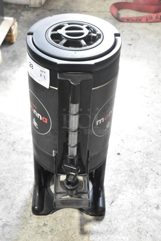 Industrial coffee urn, labeled "Café Manna," black with chrome dispenser. Auction tag shows "Qty x2" for double bid.