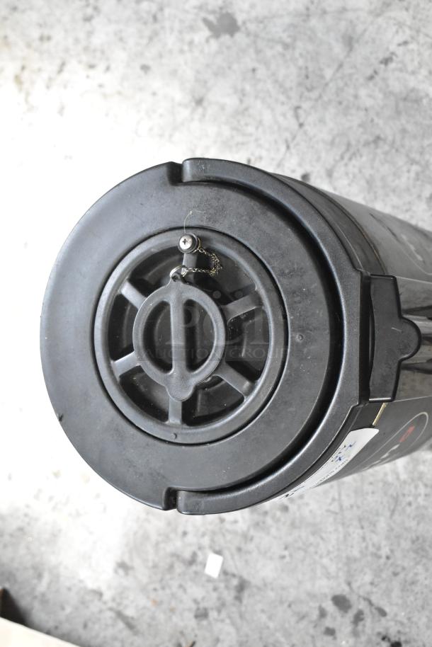 Alt text: Top view of a black satellite server with a circular lid, showcasing a metal latch and chain. Auction item includes two units.