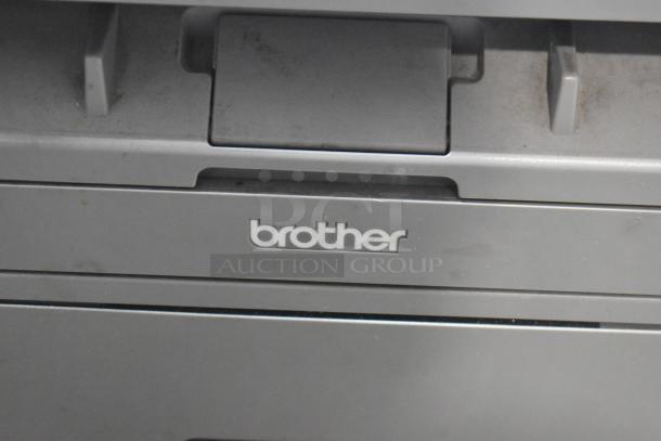 Brother MFC-L2700DW printer, scanner, copier on countertop. Visible logo, minor wear. Ideal for home office use.