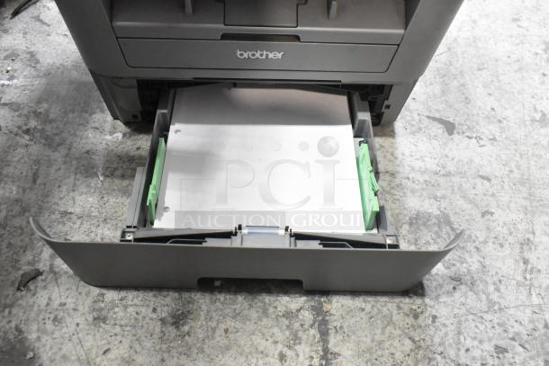 Brother MFC-L2700DW scanner copier printer, open paper tray visible, used condition, brand name marked on device.