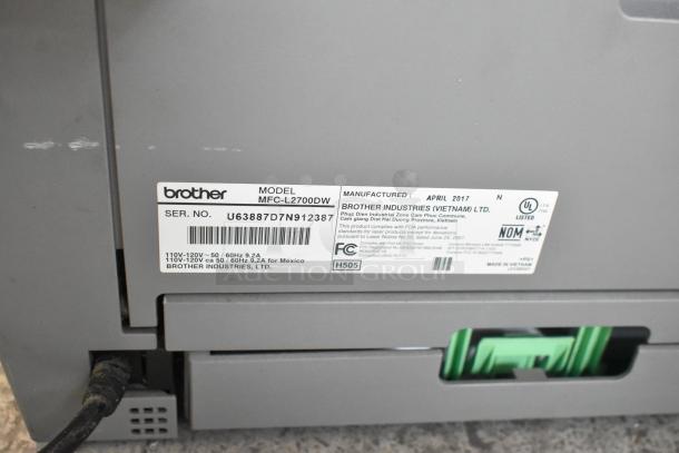 Brother MFC-L2700DW printer, model label visible, serial no. U63887D7N912387, manufactured April 2017 in Vietnam.