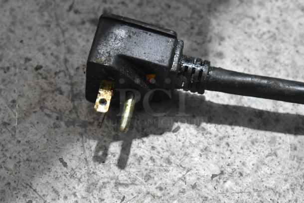 Close-up of a black plug for the Adcraft DF-12L deep fat fryer, showing minor wear.