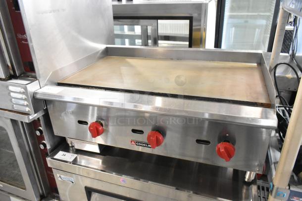 Cookline stainless steel commercial gas griddle with flat top, red knobs, in good condition, model number visible.