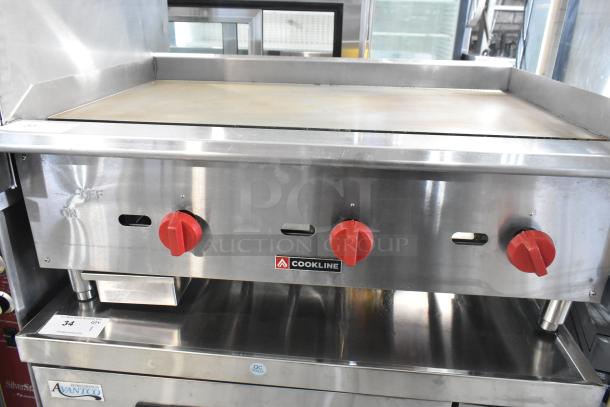 Cookline stainless steel commercial countertop gas griddle with red control knobs, used condition, visible Cookline branding.