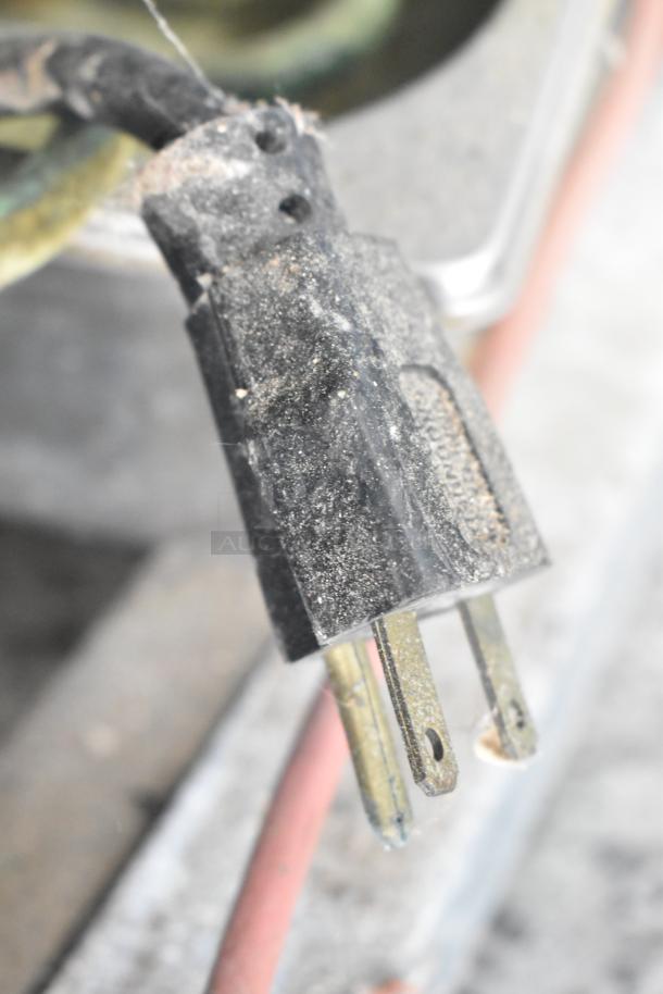 Close-up of a dusty electrical plug for a Sifa GAEP6L096N0710 Reach-In Merchandiser, showing signs of wear.
