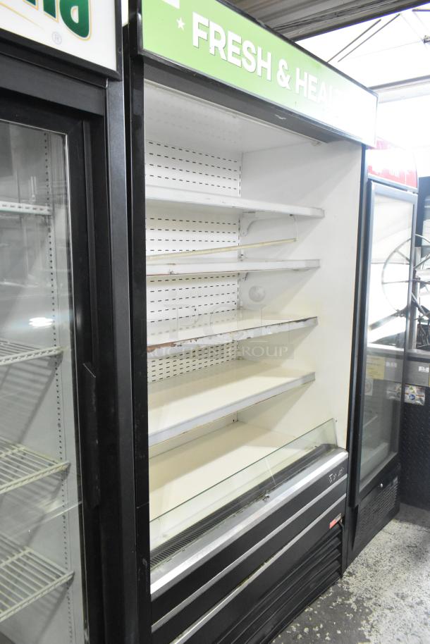 Turbo Air TOM-48E commercial open merchandiser. Metal build, shelves, 115 volts, 1 phase. "Fresh & Healthy" sign on top.