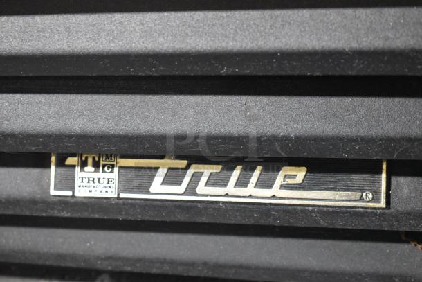 True GDM-45-LD logo on metal commercial 2-door reach-in cooler merchandiser.
