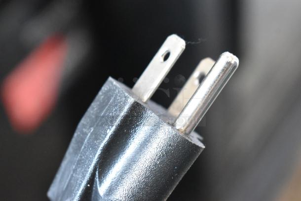 Close-up of a plug for the Frigidaire FGFRF7009-B-BLACK chest freezer, showing prongs and black casing.