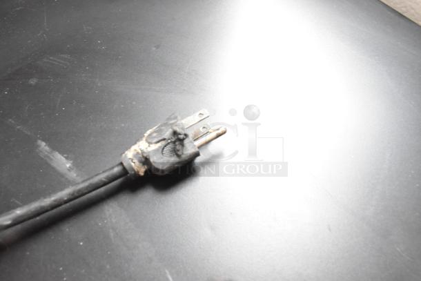 Damaged electrical plug of Galanz GL43S5 Mini Cooler shown on dark surface. Plug requires repair or replacement.