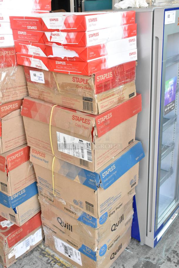 Stack of Staples copy paper boxes with mixed conditions, includes additional 8 reams; ideal for office supply needs.