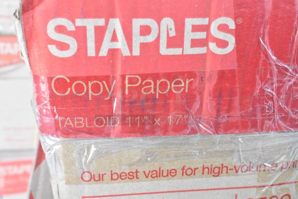Staples copy paper box, 11" x 17" tabloid size, partial label visible, wrapped in clear plastic.
