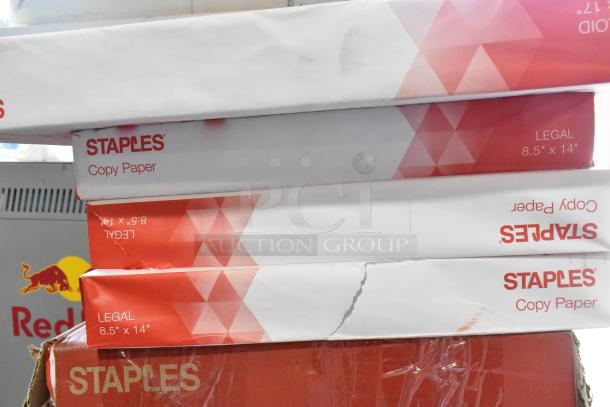 Five boxes of Staples copy paper, 8.5" x 14", legal size, with an extra 8 reams. Some visible wear on packaging.