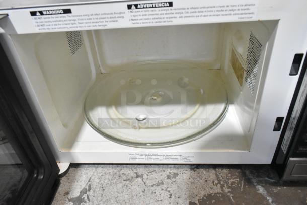 Panasonic NN-SN661S stainless steel countertop microwave oven interior with glass plate, visible warning labels. Used condition.