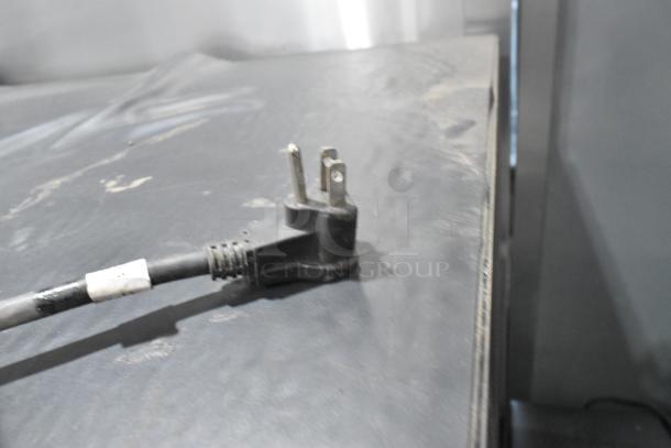 Power plug of Imbera VR10 cooler on dark surface. No visible tags or markings on plug.