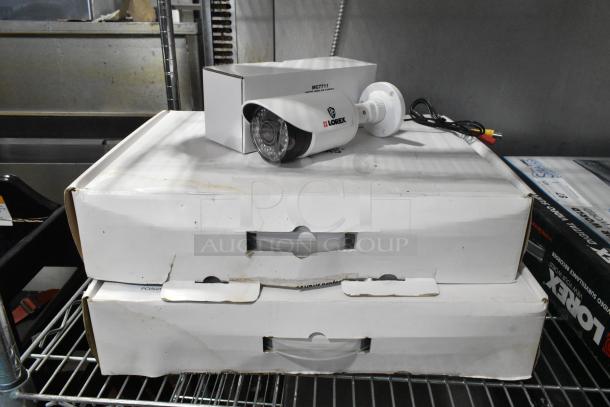Two boxes of Lorex CVC7711PK4B cameras, new condition, with original packaging. Ideal for enhancing security systems.