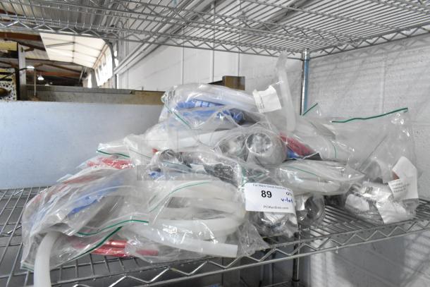 Lot of brand new silicone hoses and stacking kits in plastic bags on a metal shelf. Auction lot 89, PCI Auctions label visible.