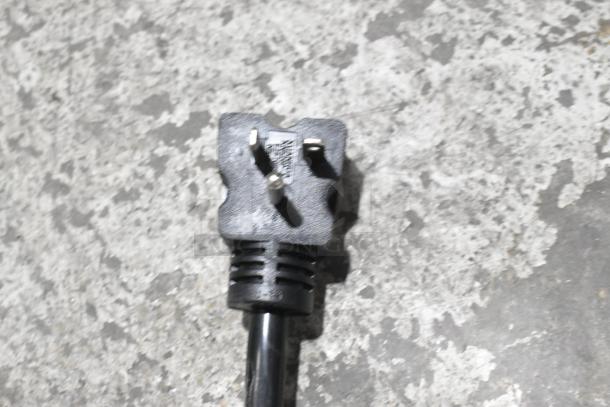 Close-up of a plug with a black cable on a stone surface, likely part of the Avantco 184T140 conveyor toaster.