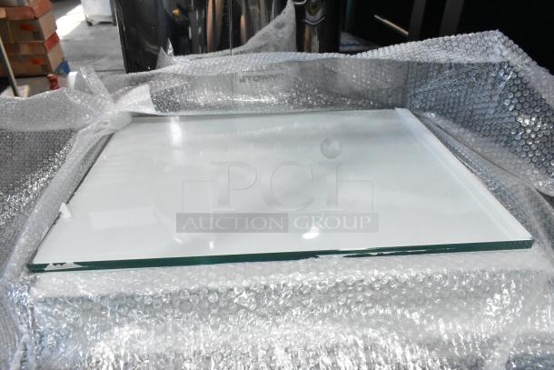Six brand new scratch and dent glass panes, wrapped in bubble wrap, ready for auction.