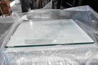 Six brand new scratch and dent glass panes, wrapped in bubble wrap, ready for auction.