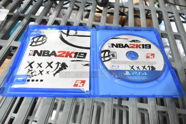 PS4 NBA 2K19 game in open blue case with disc and booklet. Includes headphones, PlayStation controller, and earphones.