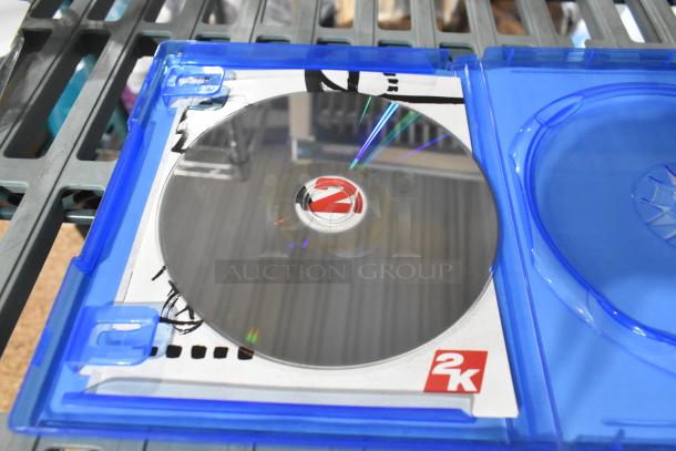 PS4 NBA 2K19 game disc in blue case, visible 2K logo. Auction lot includes headphones, PlayStation controller, and earphones.