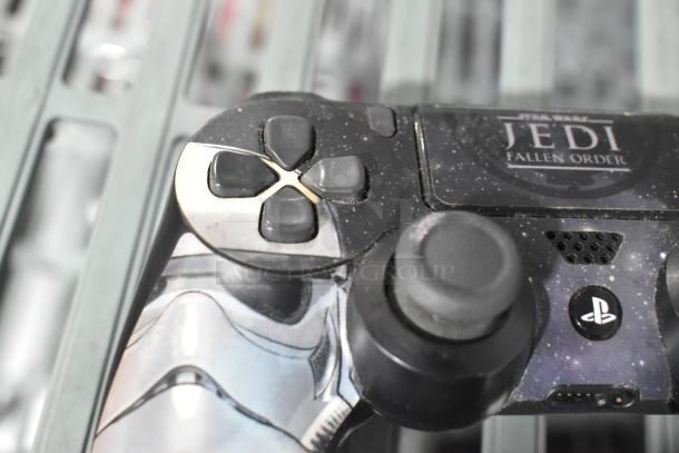PlayStation controller with Star Wars: Jedi Fallen Order design, showing D-pad and buttons, minor wear visible.