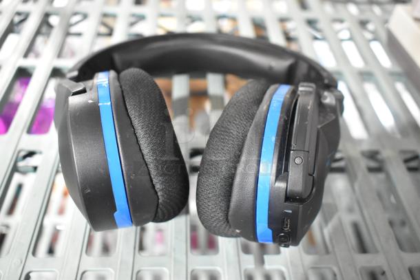 Headphones with black and blue design, padded ear cushions, and visible control buttons on the side.