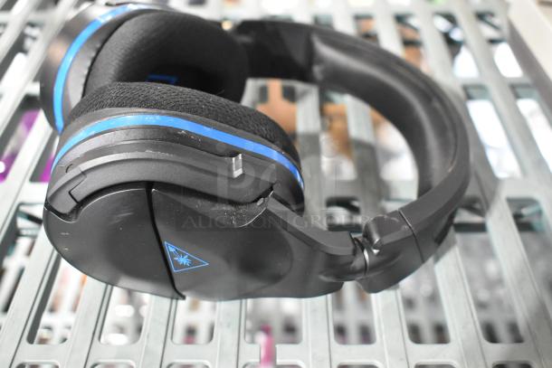 "Black Turtle Beach headphones with blue accents, showing light wear. Part of a lot including PS4 NBA 2K19, controller, and earphones."