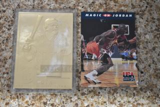Babe Ruth card with embossed gold-tone image in protective case, alongside a Magic Johnson vs. Michael Jordan basketball card.