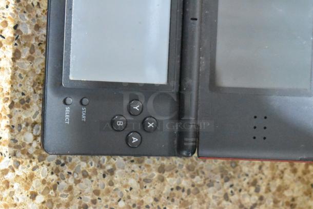 Close-up of a Nintendo DS game console showing buttons and screens. Includes Coolbaby RS-41, Matchbox Cars, and three games.