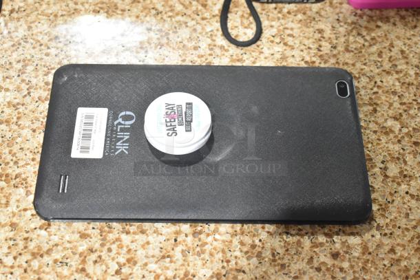 Black Scepter tablet with QLink branding. Minor wear visible. Includes attached Safe2Say label. Suitable for bidding.