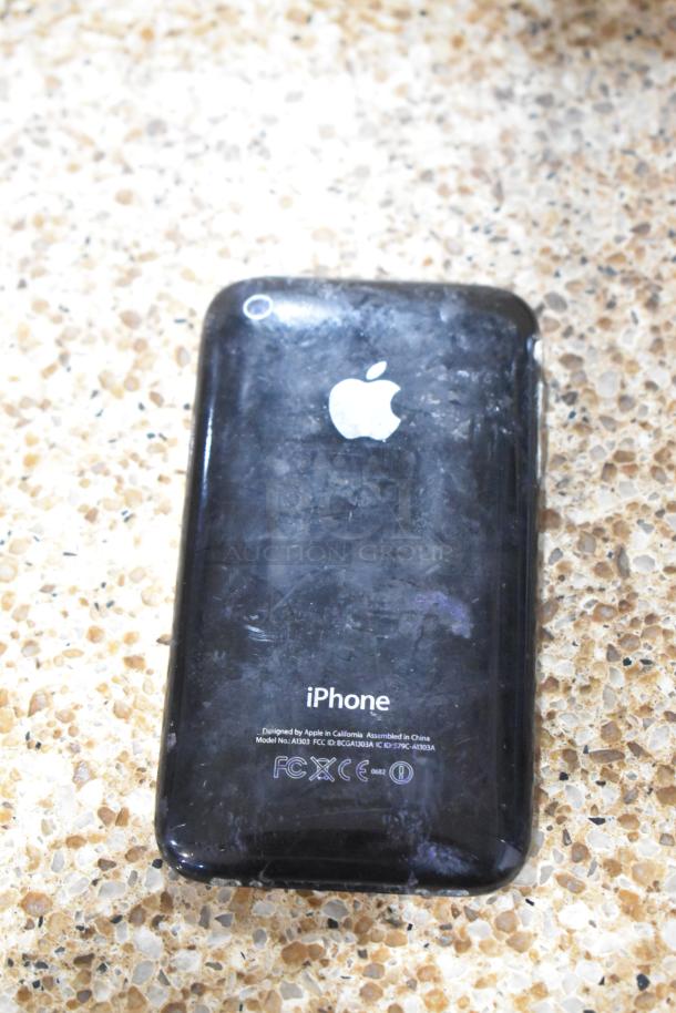 "Apple iPhone A1303 back view, showing wear and scratches, with visible Apple logo and model details."