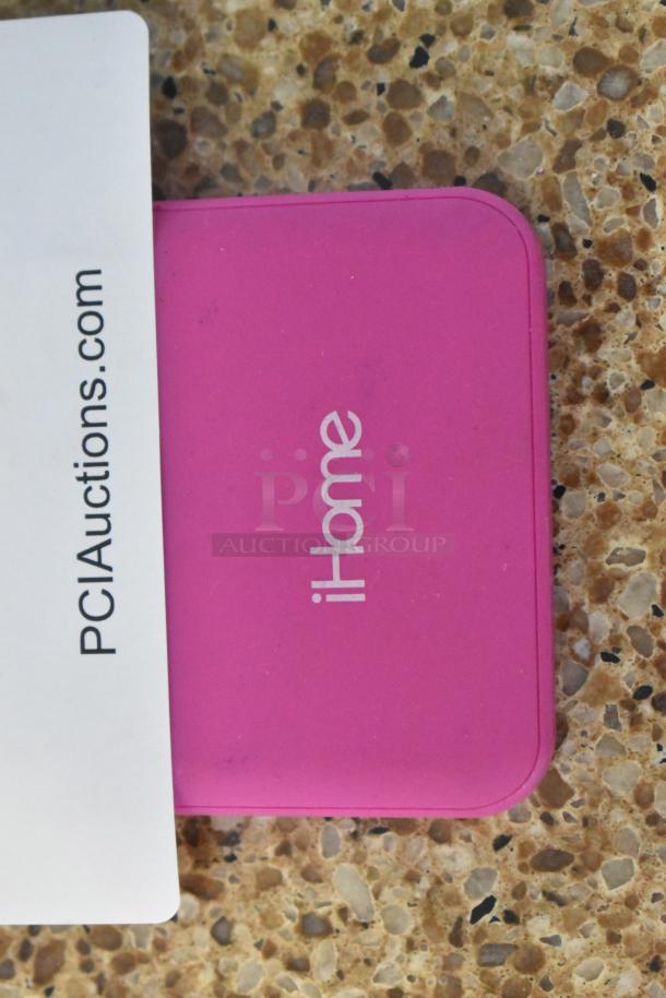 Pink Apple IH-W-PP2058 iHome device on a speckled surface, partial view of PCIauctions.com tag.