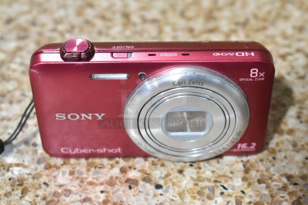 Sony Cyber-shot digital camera, red, features 16.2 MP, 8x optical zoom, Carl Zeiss lens, with visible wear on body.