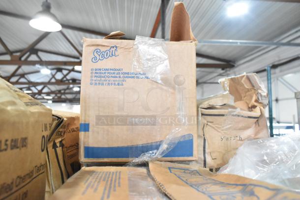 Cardboard box labeled "Scott" containing skin care products, part of a mixed two-tier auction lot. Boxes show signs of wear.