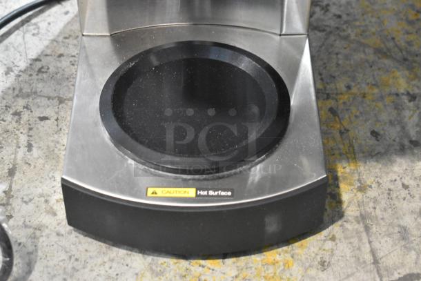 Avantco 177C10 stainless steel coffee maker warmer, showing "Caution: Hot Surface" label, scratch and dent condition.