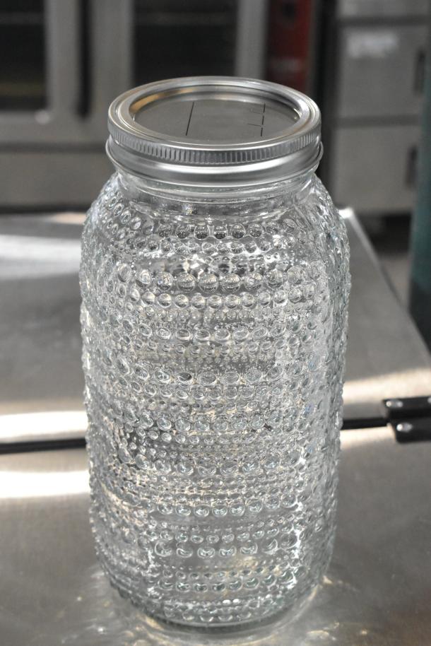Clear textured glass jar with metal lid, part of 9 scratch-and-dent items. New condition.