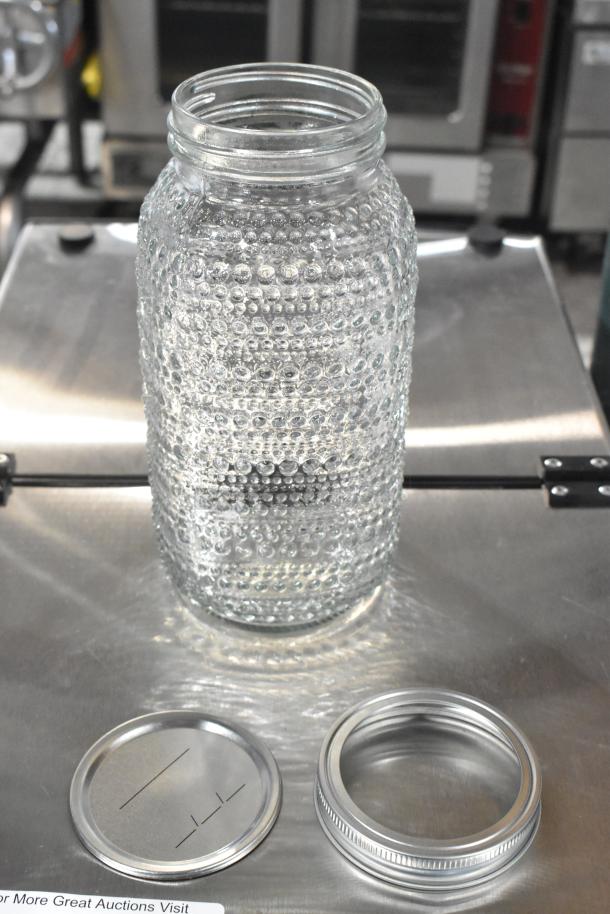 Textured glass jar with lid components, brand new, clear design, suitable for decor or storage, part of a 9-piece auction lot.