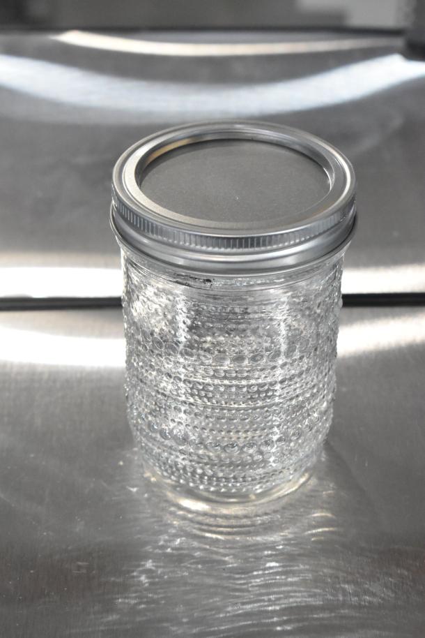 New textured glass jar with metal lid, part of a lot including 9 scratch and dent items. Great condition, ideal for bids.