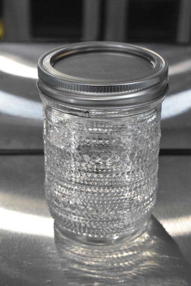 Brand new textured glass jar with metal lid, part of 9 scratch and dent items. Appears unused, potential high value lot.
