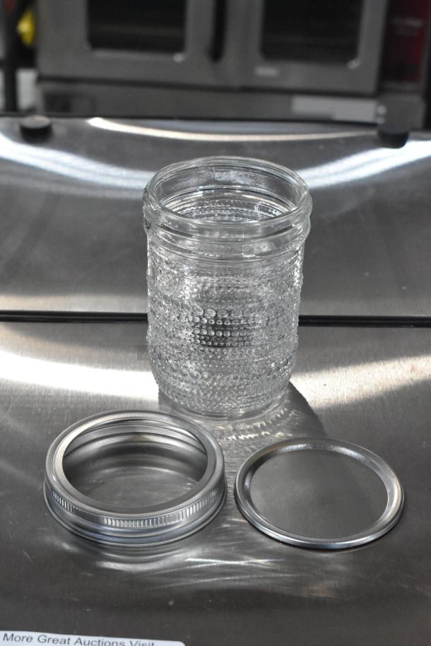 Glass jar with textured design, includes lid and ring, part of 9 brand new scratch and dent items. Auction detail visible.
