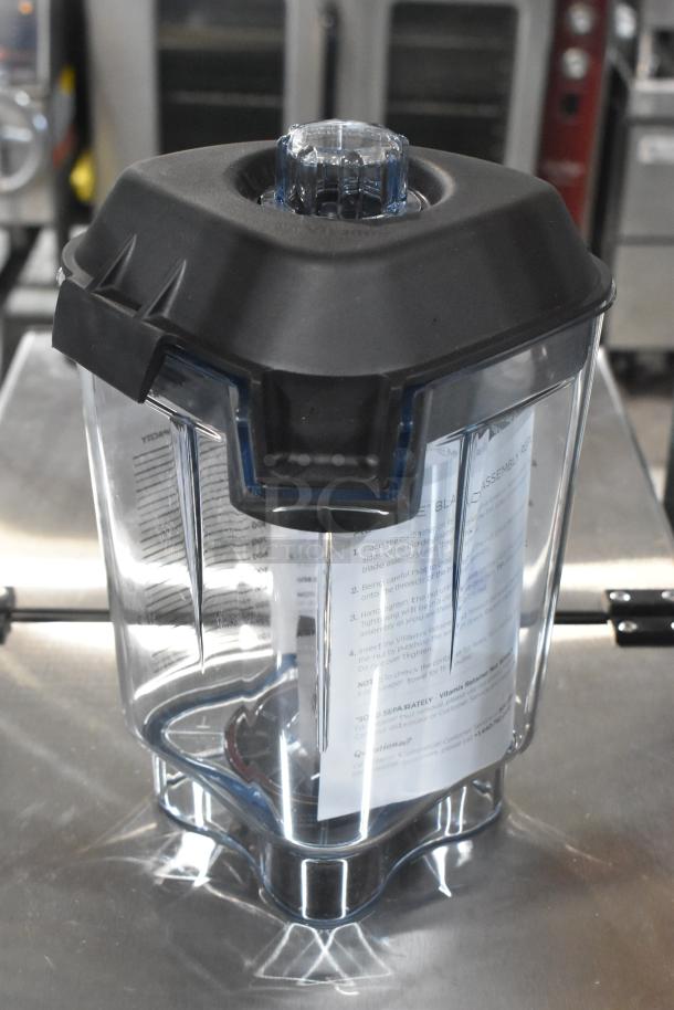 Brand new blender pitcher with black lid, clear body, and instruction sheet inside. No visible scratches or dents.